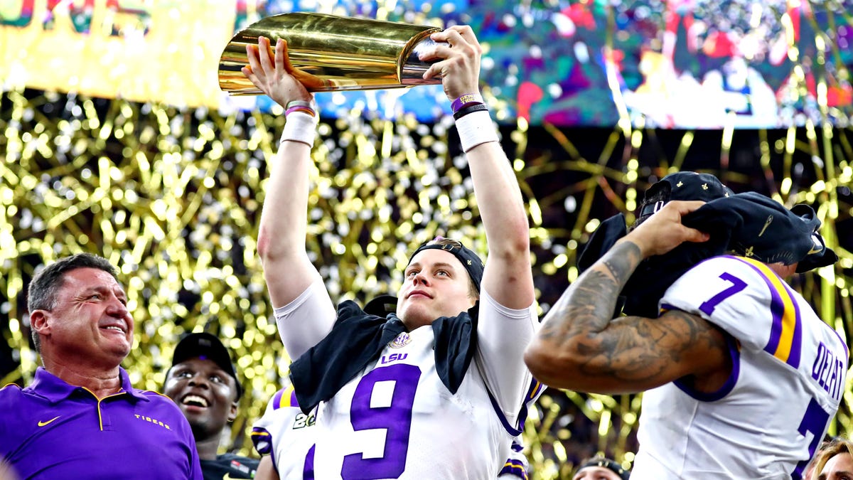 LSU Tigers head coach Ed Orgeron and LSU Tigers quarterback Joe Burrow (9) celebrate with the National Championship trophy after beating Clemson Tigers in the College Football Playoff national championship game at Mercedes-Benz Superdome.