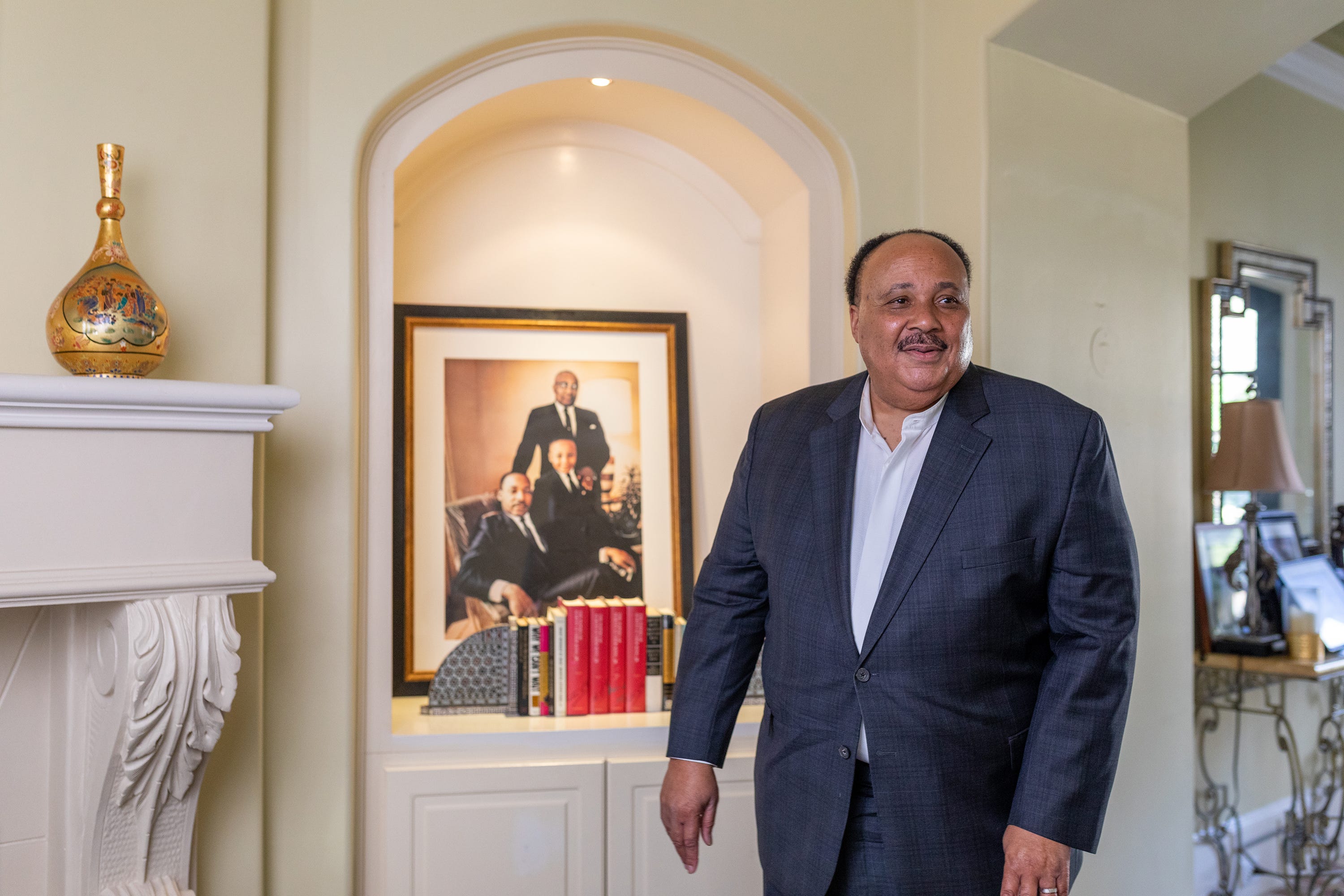 Martin Luther King III stands in front of a portrait of him and his father, Martin Luther King Jr.