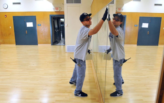 A custodian at Haydock Academy of Arts and Sciences is seen cleaning mirrors in a dance studio when the school was remodeled in 2014. The district is planning to rename the school, getting rid of the Haydock moniker.