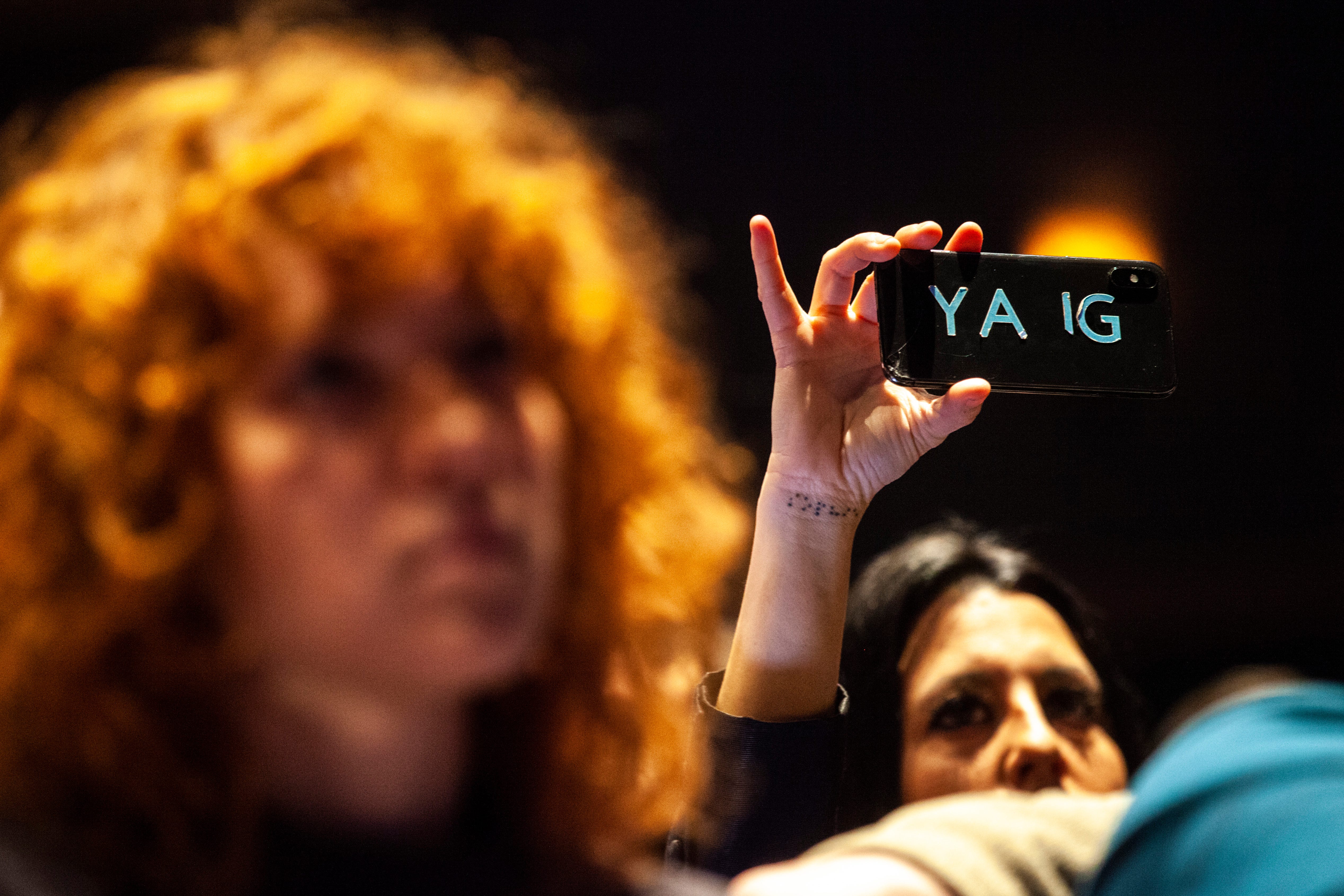 A supporter holds up a phone while Democratic presidential candidate Andrew Yang speaks during the "Women's Town Hall," Saturday, Jan. 18, 2020, at the Englert Theatre in Iowa City, Iowa.