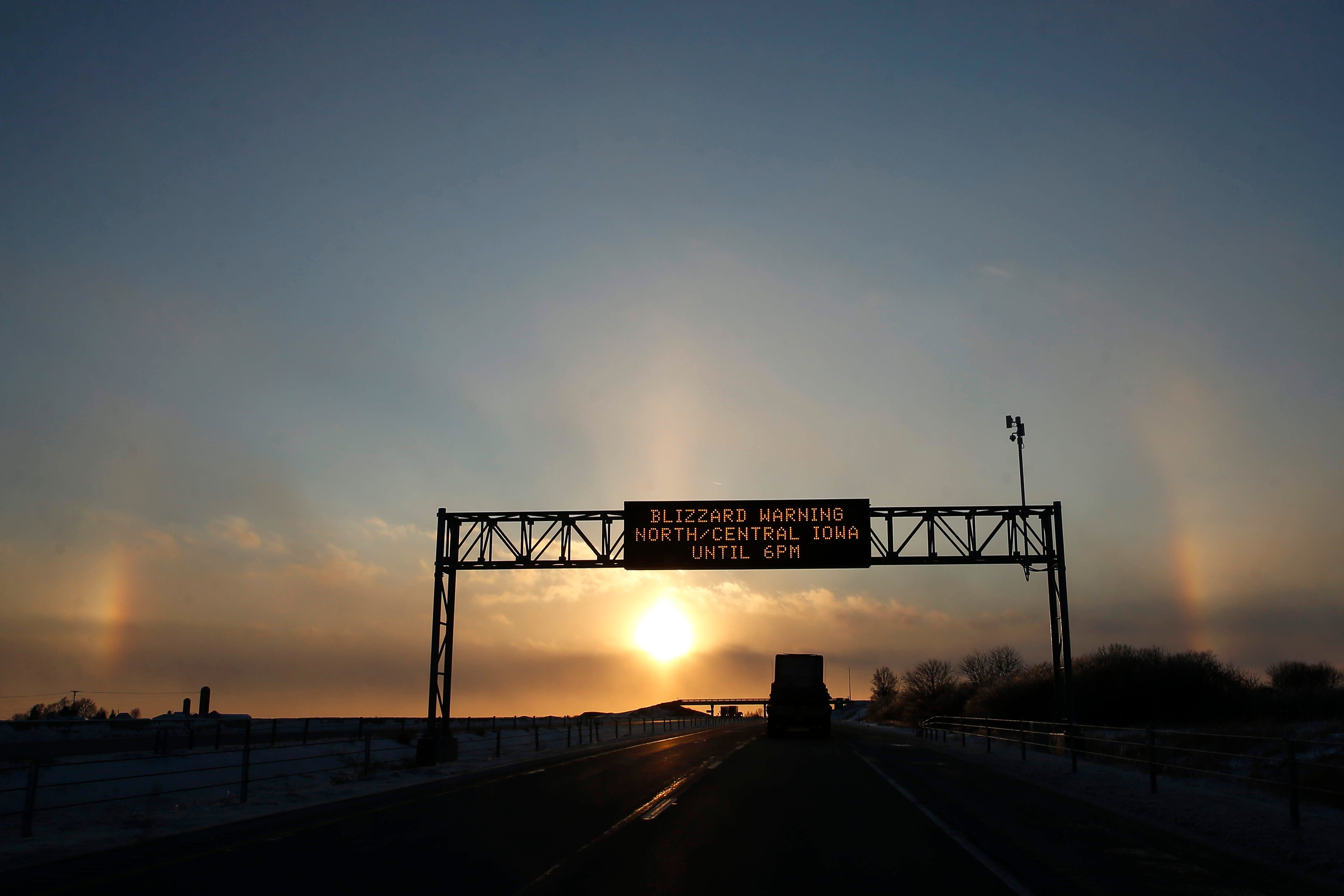 4:44 p.m., Newton — A large sundog arches over an Iowa Department of Transportation sign cautioning motorists about a blizzard warning in much of central and northern Iowa. Sundogs occur when there are ice crystals in the atmosphere, creating orbs on both sides of the sun.