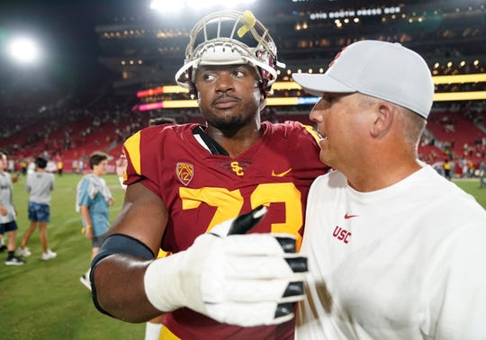 Southern California Trojans head coach Clay Helton (right) and offensive tackle Austin Jackson (73) embrace after the game against the Fresno State Bulldogs at Los Angeles Memorial Coliseum. USC defeated Fresno State 31-23.
