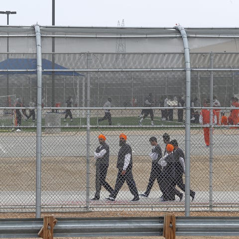 Detainees walk around outside at the U.S. Immigrat