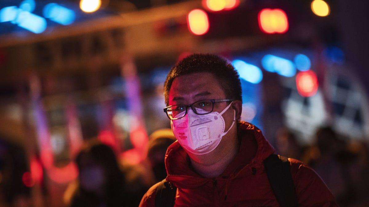 A Chinese man wears a protective mask as he arrives to board a train at Beijing Railway station before the annual Spring Festival on January 21, 2020 in Beijing, China. The number of cases of a deadly new coronavirus rose to nearly 300 in mainland China on Tuesday as health officials stepped up efforts to contain the spread of the pneumonia-like disease.