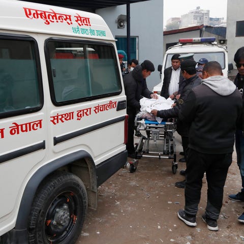 Hospital staff load bodies of Indian tourists into