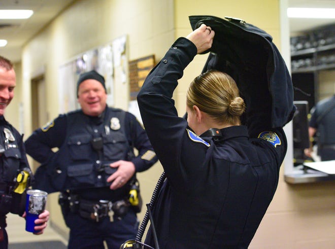 Officer Jenifer Suurmeyer tosses on her coat before leaving the office on Thursday, Jan 23, at the Law Enforcement Center in Sioux Falls. 