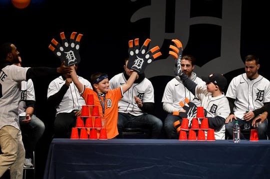 Domonic Hamden, 10, of St. Clair Shores, high-fives Matthew Biggs, 9, of Taylor, left, after Biggs won the race to make a tower of plastic cups as the Tigers look on Thursday.