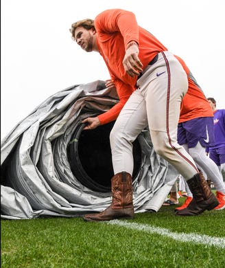 Clemson sophomore Chad Fairey(35) helps roll up the rain tarp before their first official team Spring practice at Doug Kingsmore Stadium in Clemson Friday, January 24, 2020.