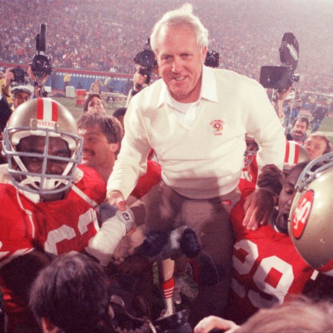 Bill Walsh is hoisted on the shoulders of his team
