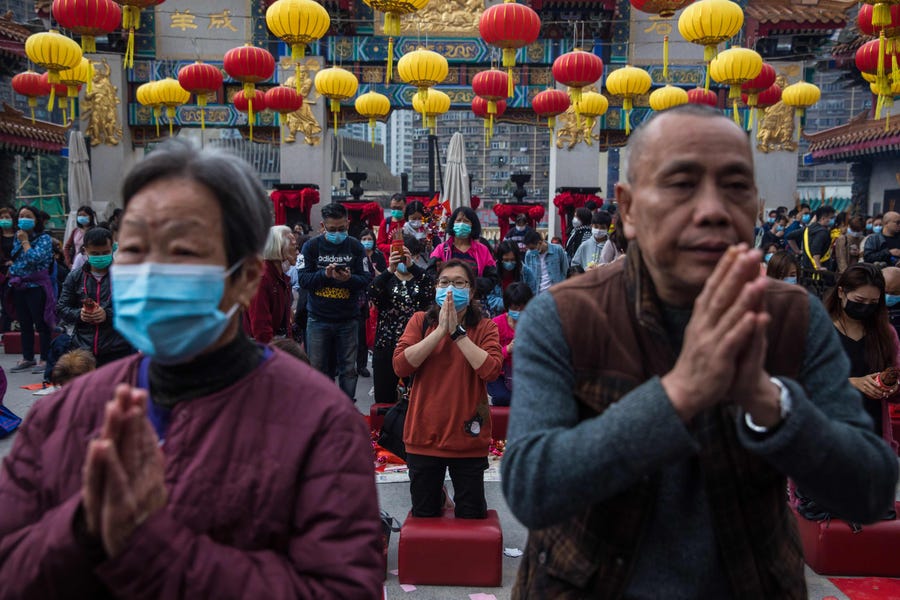 People wear masks as they pray at Wong Tai Sin temple on the first day of the Lunar New Year of the Rat in Hong Kong on January 25, 2020, as a preventative measure following a coronavirus outbreak which began in the Chinese city of Wuhan. 