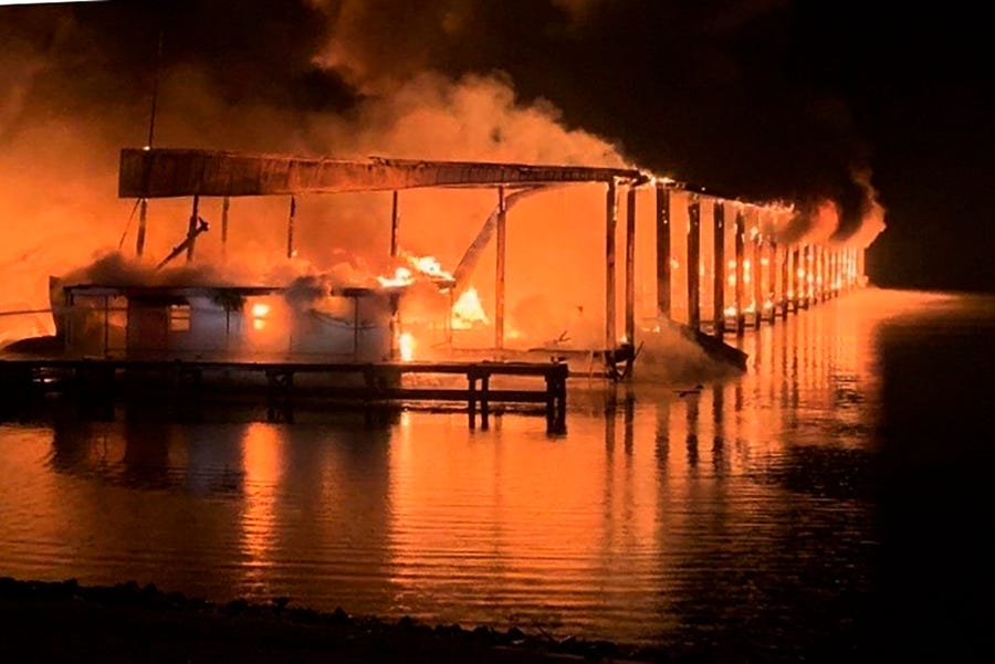A fire burns on a dock where at least 35 vessels, many of them houseboats, were destroyed by fire early Monday, Jan. 27, 2020, in Scottsboro, Ala. Scottsboro Fire Chief Gene Necklaus is confirming fatalities in a massive fire at a boat dock.