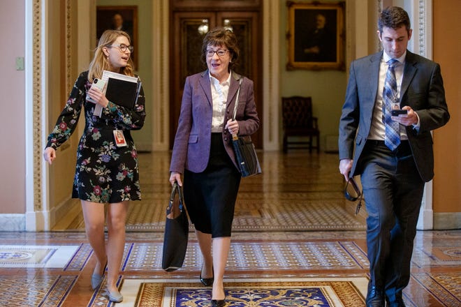 Sen. Susan Collins, R-Maine, (center) walks through the Ohio Clock Corridor in the U.S. Capitol on Jan. 27 in Washington, DC.