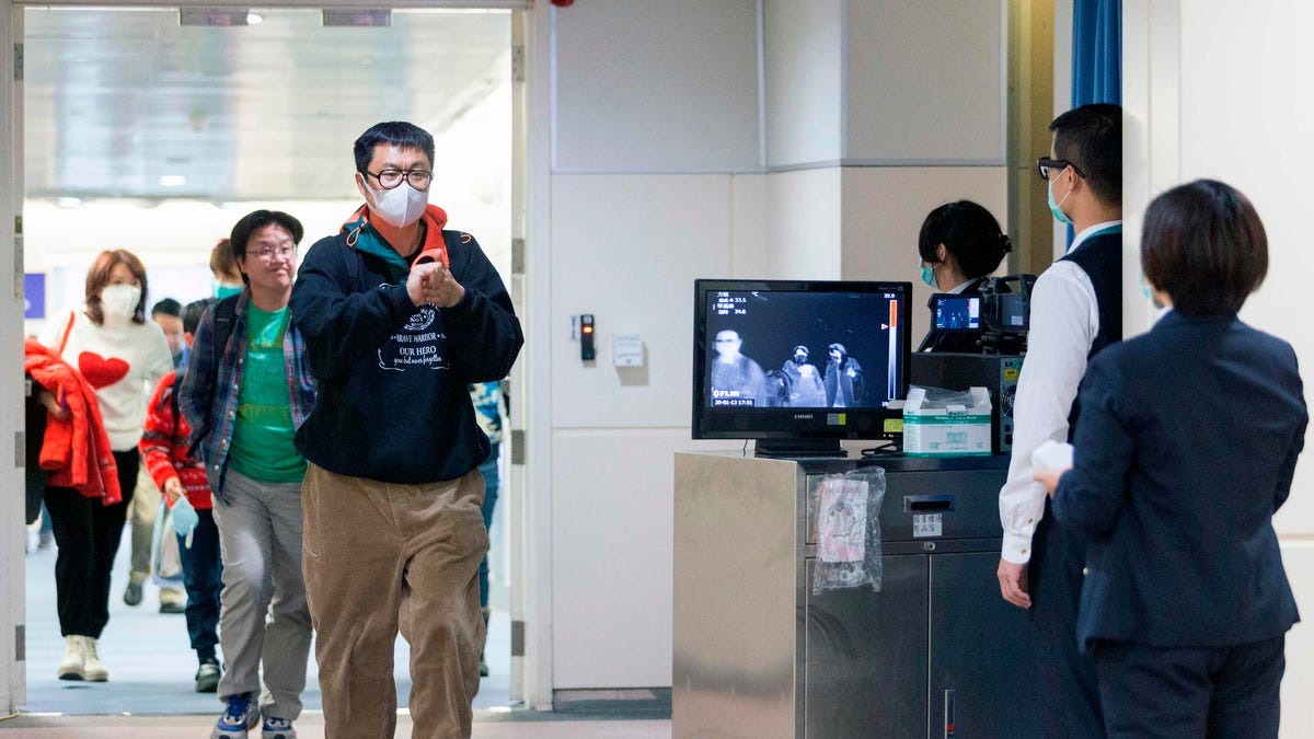 Staff from Taiwan's Center for Disease Control use thermal scanners to look for fevers among passengers arriving from Wuhan on Jan. 13, a week before the Chinese government began its lockdown efforts to contain coronavirus.