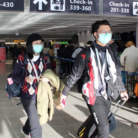 Chinese passengers wear face masks as they depart 