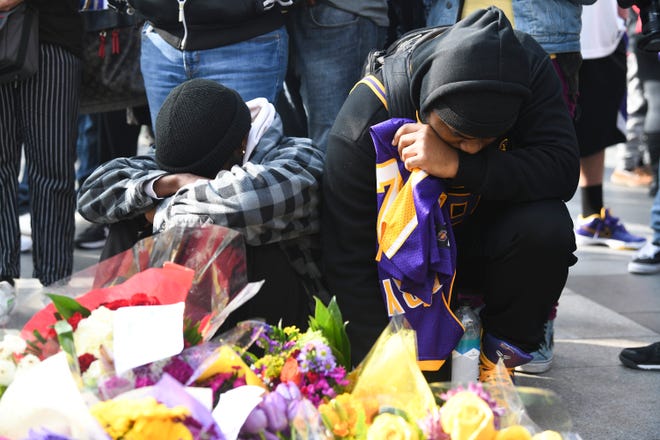 Fans Mourn the loss of NBA legend Kobe Bryant outside of the Staples Center in Los Angeles.