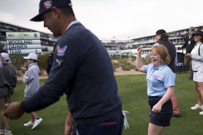 Amy Bockerstette  (right) walks the 16th hole at the 2020 Waste Management Phoenix Open with golfer Gary Woodland (left) in Scottsdale, Ariz. on January 29, 2020. Bockerstette went viral in 2019 when she golfed at the Phoenix Open and later started a foundation for people with with Down syndrome and other intellectual disabilities called "I got this."