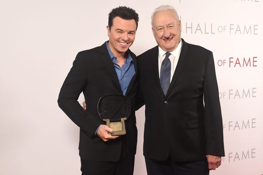 Actor-writer-animator Seth MacFarlane, left, poses Tuesday with director Don Mischer and his Television Academy Hall of Fame statuette, which the "Family Guy" creator said he planned to use to tip the valet after Tuesday's Television Academy Hall of Fame ceremony in Los Angeles.