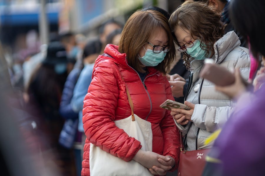 People line up to receive free face masks to protect themselves against the Wuhan coronavirus at a pharmacy in Tsuen Wan, Hong Kong, China on Jan. 28, 2020. 