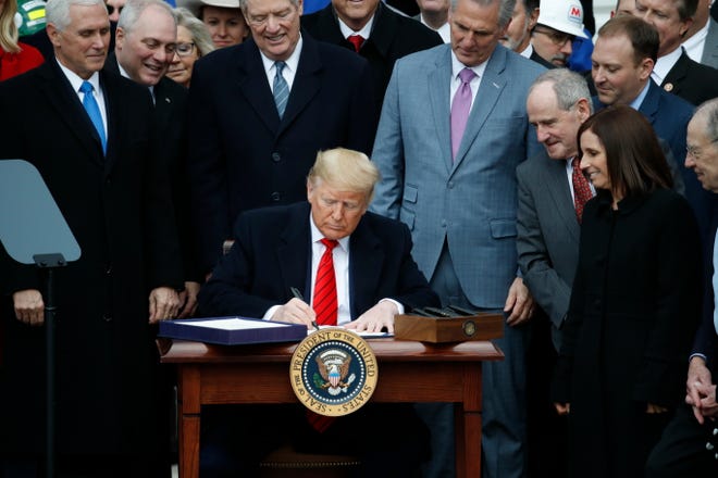 Declaring “a colossal victory” for American workers, President Donald Trump signs the United States-Mexico-Canada Agreement, or USMCA, on Jan. 29 at the White House.