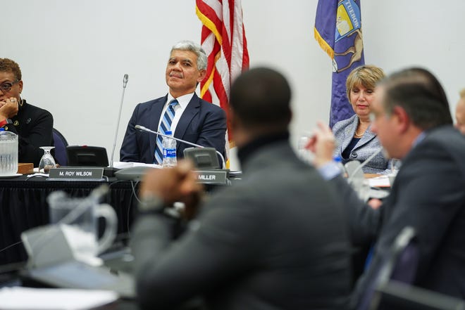 Wayne State University President M. Roy Wilson listens to Board of Governors member Michael Busuito comment during a public meeting at McGregor Memorial Conference Center in December.