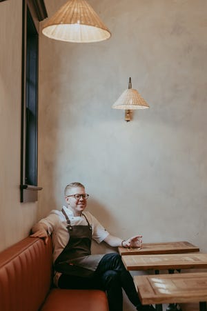 Hunter Evans sits at a table in the dining area of his Jackson restaurant Elvie's.