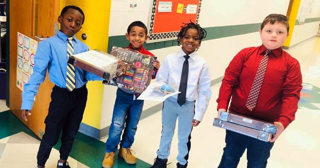 McKinley Elementary students and new Boys with a Purpose club members, (left to right) Victor Wilson, Jayden Thompson, Shamoz Moore and Garrett Bruglar, deliver rewards to fellow students. The new club is an initiative to help boys at McKinley learn about leadership, kindness and respect.