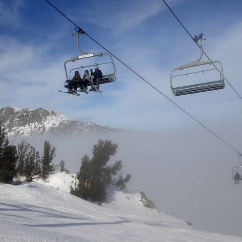Skiers emerge from a fog and smog layer at the 9,7