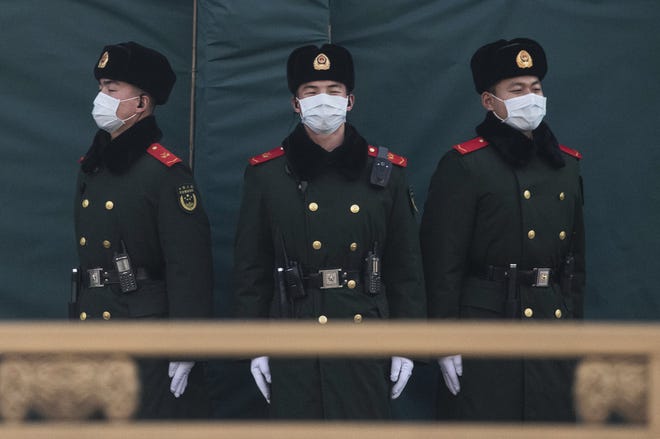 Chinese police wear protective masks as they stand guard on a main road on January 31, 2020 in Beijing, China.