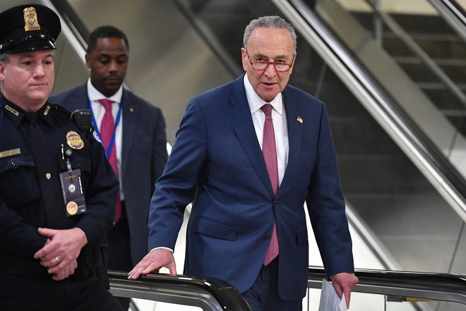 Senate Minority Leader Chuck Schumer, D-N.Y., makes his way to speak to reporters near the Senate subway during a break in the impeachment proceedings against President Donald Trump on Friday.