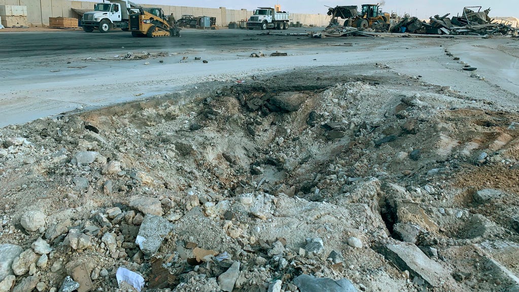 In this Jan. 13, 2020 file photo, Iranian bombing caused a crater at Ain al-Asad air base in Anbar, Iraq. Ain al-Asad air base was struck by a barrage of Iranian missiles, in retaliation for the U.S. drone strike that killed atop Iranian commander, Gen. Qassem Soleimani. The Pentagon now says 64 service members have been diagnosed with traumatic brain injury caused by the missile attack.