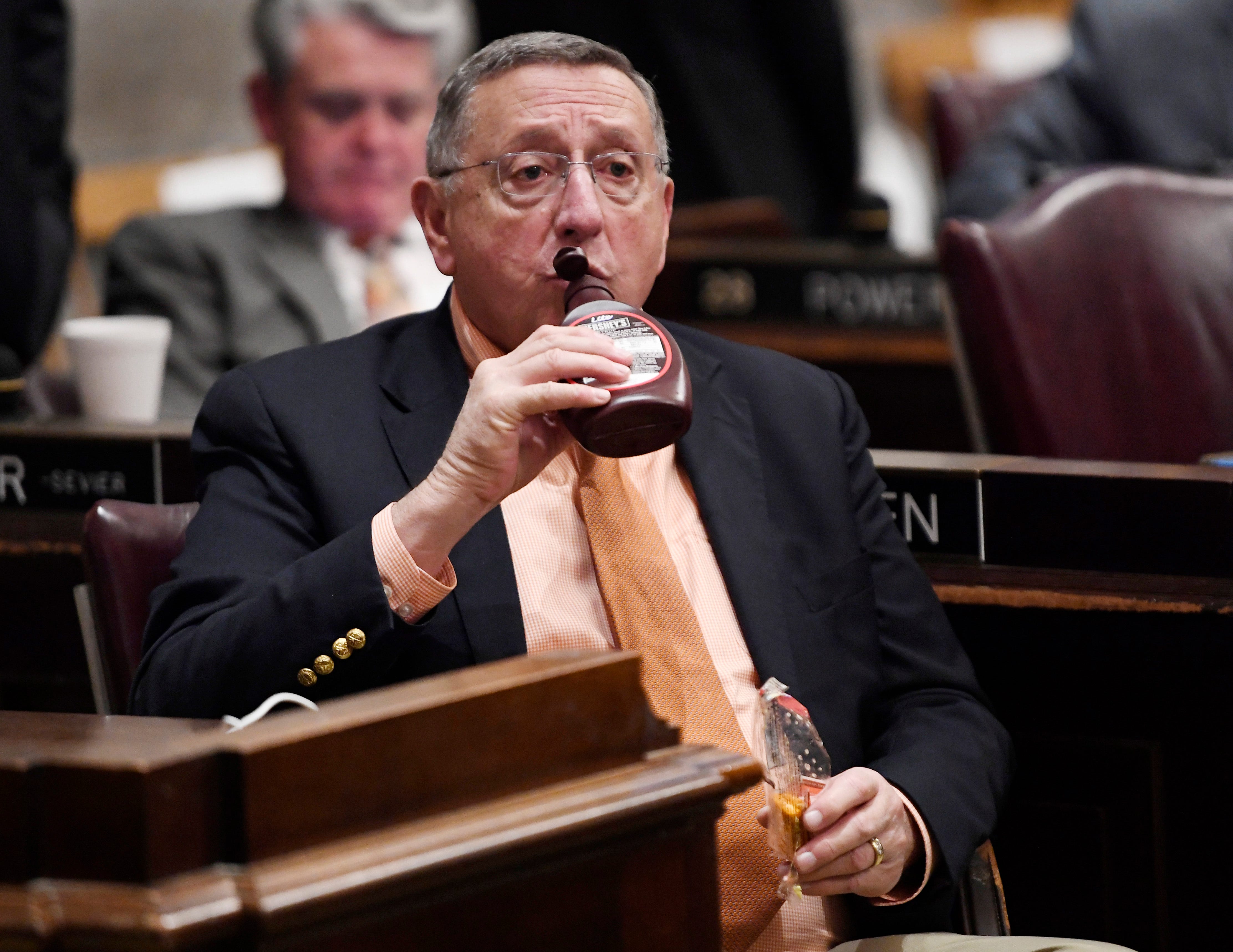 Rep. Kent Calfee, R-Kingston, drinks out of a chocolate syrup bottle as he waits for the start of the State of the State address at the state Capitol Monday, Feb. 3, 2020 in Nashville, Tenn.