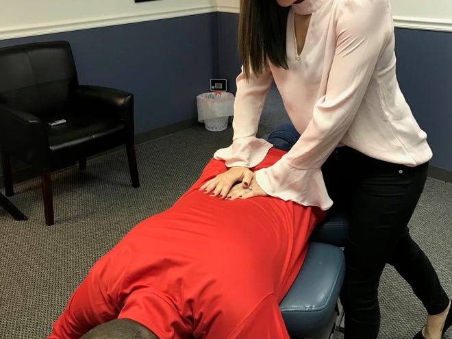 Dr. Kate Bruce, of Bruce Chiropractic, demonstrates a spinal move on her husband, Justin. The couple opened the practice at 118 E. Main St. in March 2016.