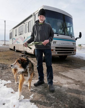 Alan Hallish poses with his dog Coolow by his new temporary motor home that was donated to him, Tuesday, February 4, 2020, in Plymouth, Wis.