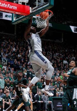 Penn State's Mike Watkins dunks on an alley-oop, over Michigan State's Gabe Brown, left, and Xavier Tillman, right, during the first half of an NCAA college basketball game Tuesday, Feb. 4, 2020, in East Lansing, Mich. (AP Photo/Al Goldis)