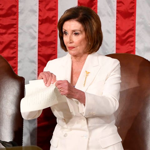 Speaker of the House Nancy Pelosi rips up a copy o