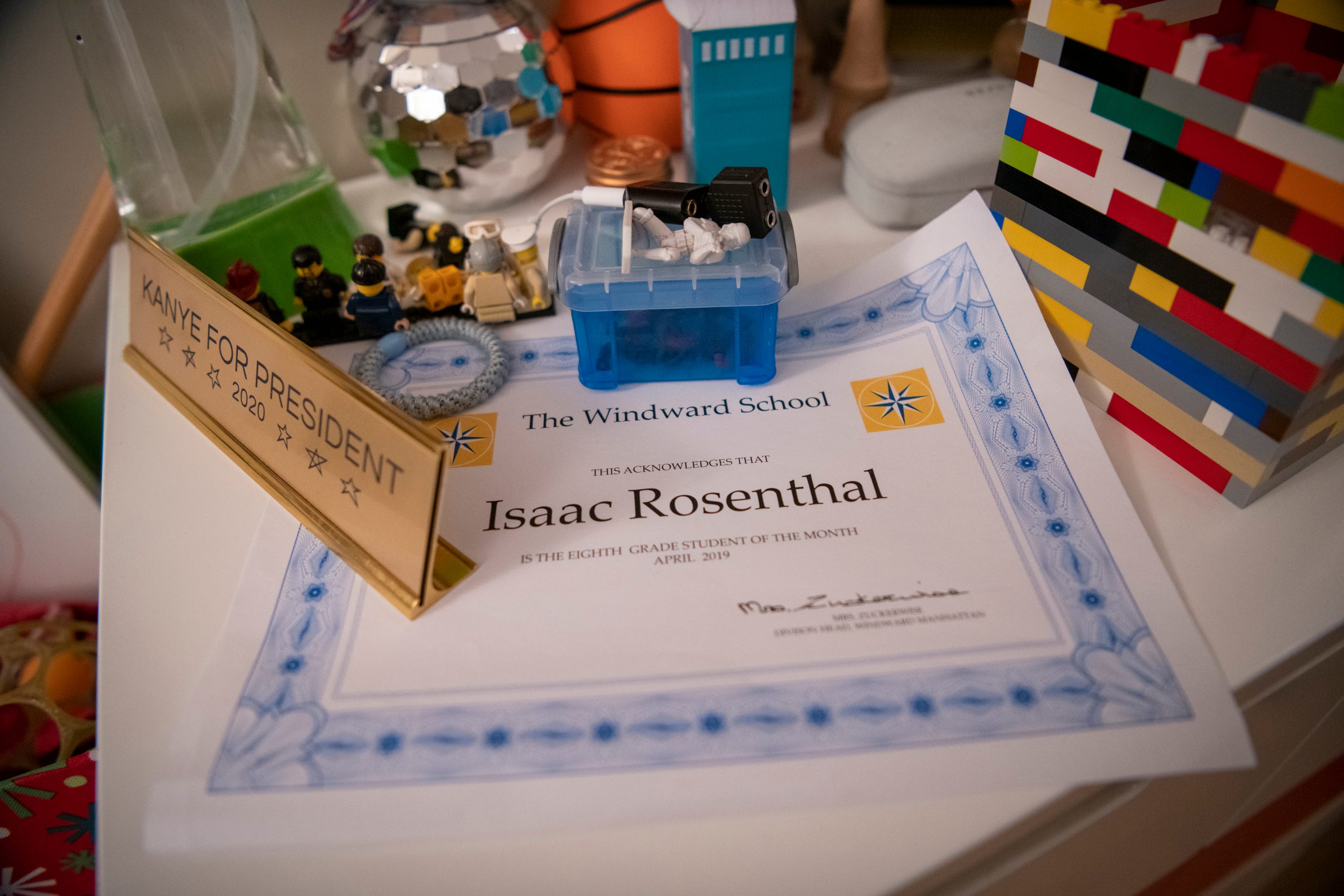 Isaac Rosenthal's award for 8th grade student of the month from April 2019 sits on the dresser in his bedroom among toys and a plaque that reads "Kanye for president 2020," which he says he got before Kanye West became a Republican.