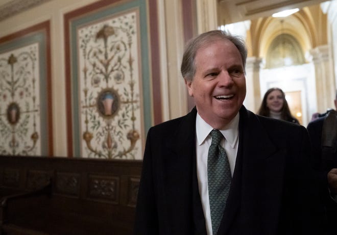 Sen. Doug Jones, D-Ala., is questioned by reporters as he arrives at the U.S. Capitol on Friday.