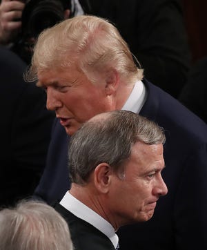 President Donald Trump passes by an unsmiling Chief Justice John Roberts before delivering his State of the Union address in the chamber of the U.S. House of Representatives on Tuesday night.