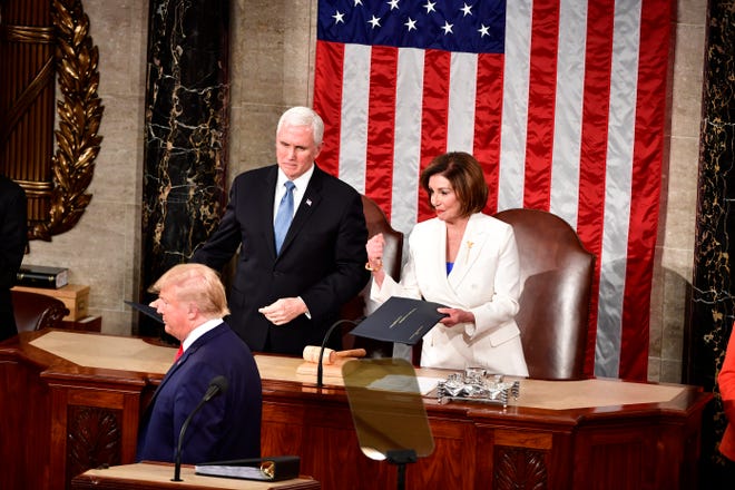 US President Donald Trump passes the written address to Speaker of the House Nancy Pelosi, but does not shake her hand before President Donald J. Trump delivers the State of the Union address from the House chamber of the United States Capitol in Washington. 