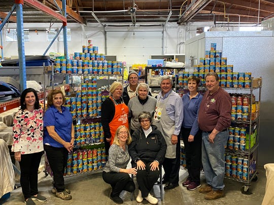 Rotarians at the food bank with the cans of soup. Pictured are Laura DePrado, Cathy Callahan, Roseann Brown, Doug Bateman (rear), Marie Scannell, Kip Bateman, Maria Donegan, and John Shockley.