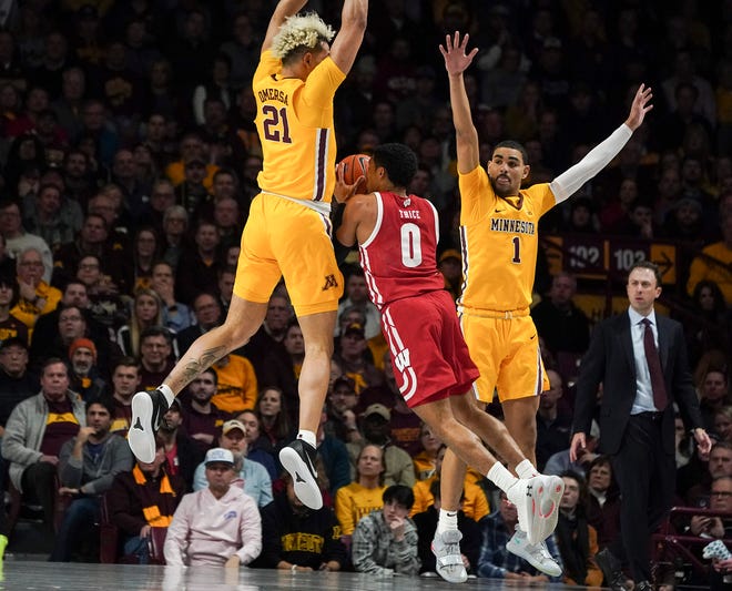Wisconsin guard D'Mitrik Trice is shut down by Minnesota's Jarvis Omersa (21) as he looks to get off a a shot during the first half.