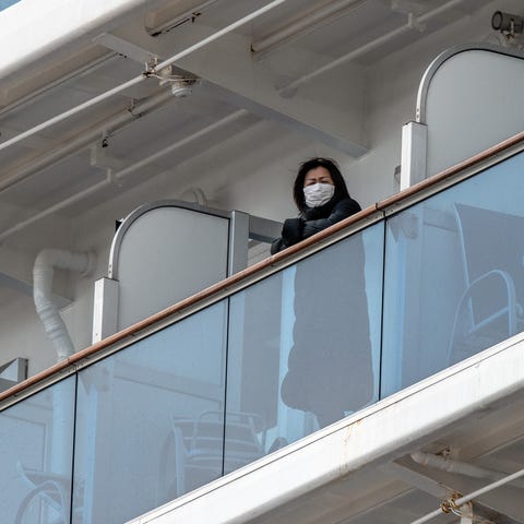 A passenger looks out from a balcony of the Diamon