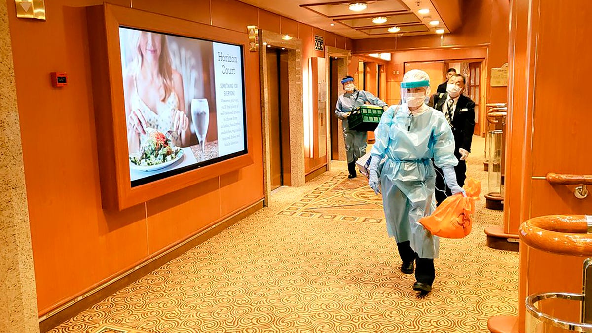 Medical workers in protective suits walk on the cruise ship Diamond Princess anchored off Yokohama, south of Tokyo, on Feb. 4, 2020.