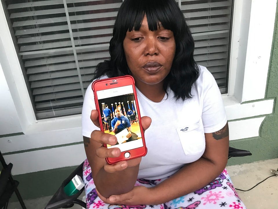 Chemeta Jundon holds cellphone bearing image of her son Franklin Reed III