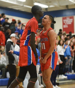 Apollo seniors Puoch Dobuol and Michael Gravelle celebrate an and-one in the first half against Tech Thursday, Feb. 6, 2020, at Apollo High School. 