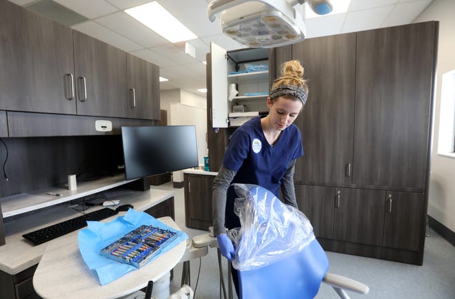 Dental hygiene student Madison Eggleston prepares a dentist's chair for a patient at Hocking College's Dental Clinic in New Lexington. The new clinic provides affordable dental care to residents as part of the college's dental hygiene program.