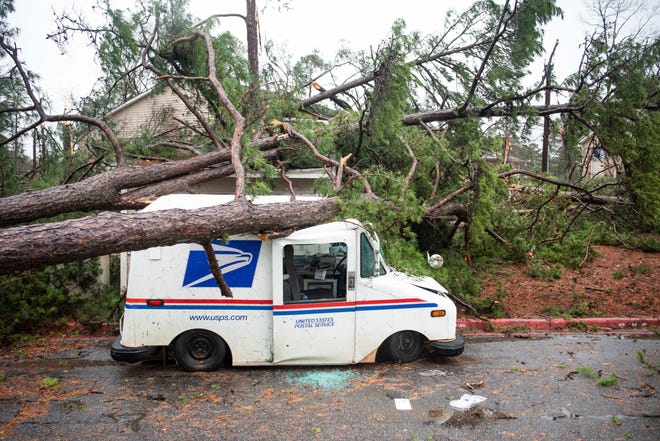 Fallen trees rest on a damaged postal truck at an apartment complex where a reported tornado passed through Thursday, Feb. 6, 2020, in Spartanburg, South Carolina. A powerful winter storm brought severe weather across the Deep South early Thursday, with high winds causing damage that killed one person, injured several others and littered at least four states.