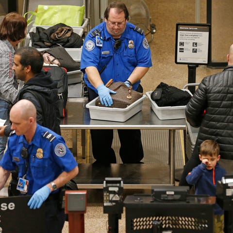 A TSA worker helps passengers at the Salt Lake Cit