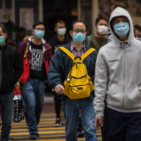 People wearing protective face masks cross a stree