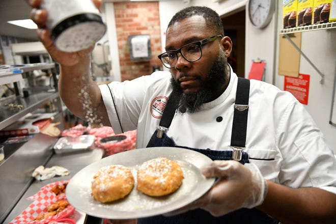 Willingboro native Timothy Witcher adds the finishing touch to an order of buttermilk-fried doughnuts at his Turnersville restaurant, The Wing Kitchen. A former 'Chopped' winner, Witcher has a new location opening on Feb. 18 in Glassboro.
